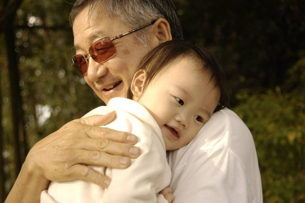 an old man holding a baby
