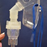 Tap the nebulizer container to release drops of medication clinging to sides