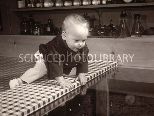 A baby on the edge of a table.