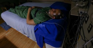 A person sleeps with sensors placed on his face.