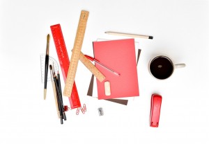 Rulers, paintbrushes, pencils, notebooks, a stapler, other office supplies and a cup of coffee.