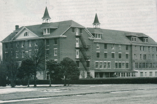 A brick building with four stories and a couple of turrets.