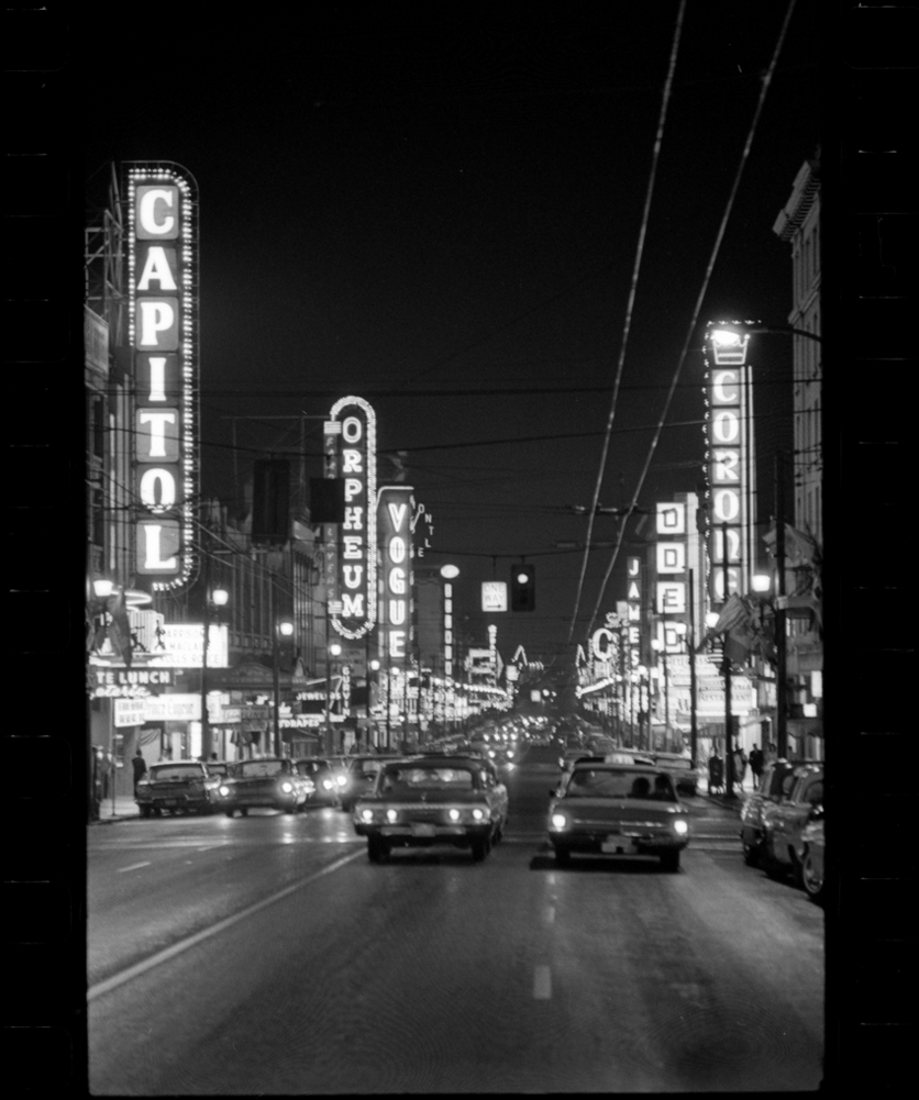 A city street lined with vertical neon signs.