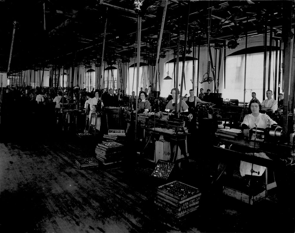 Women and men in war production in a factory.