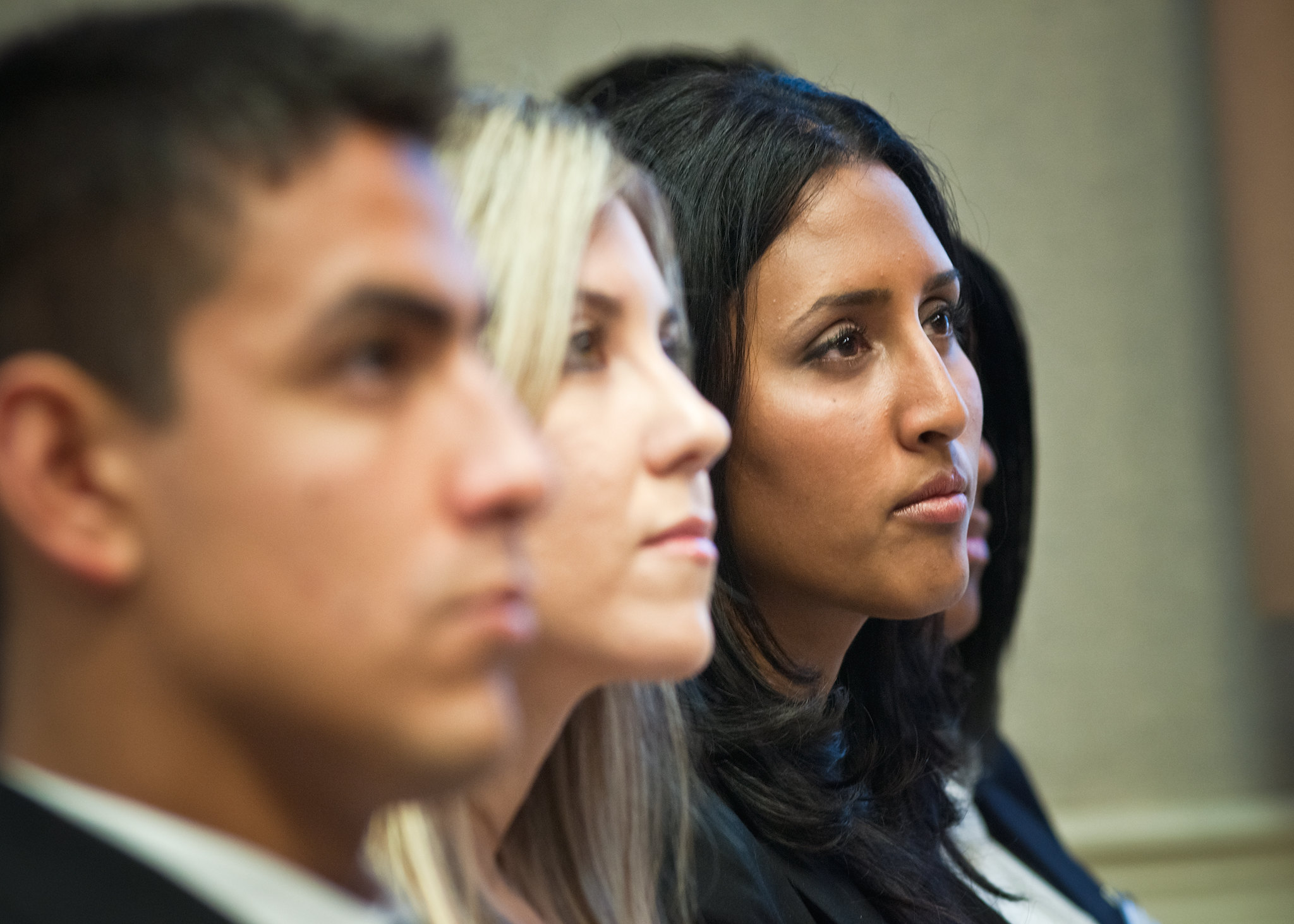 A row of people sit listening to a speaker