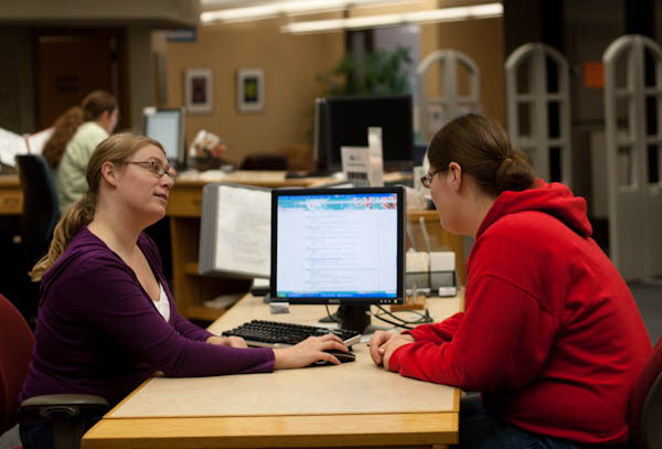 A student gets help from a librarian in how to search the library database