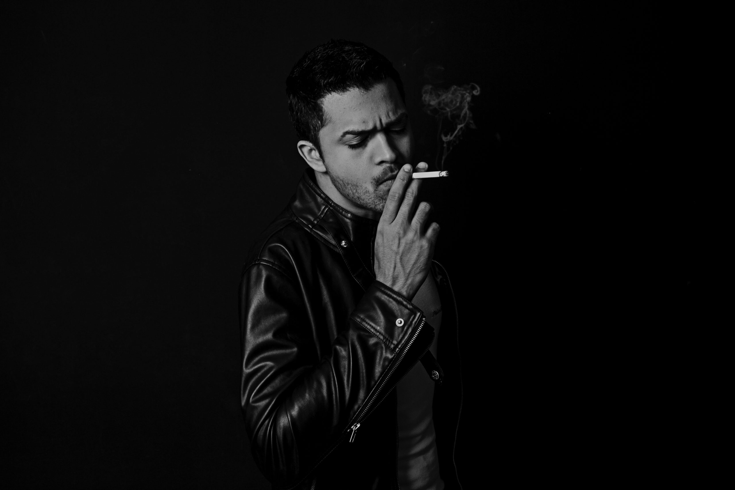 Man holding a cigarette against their mouth.