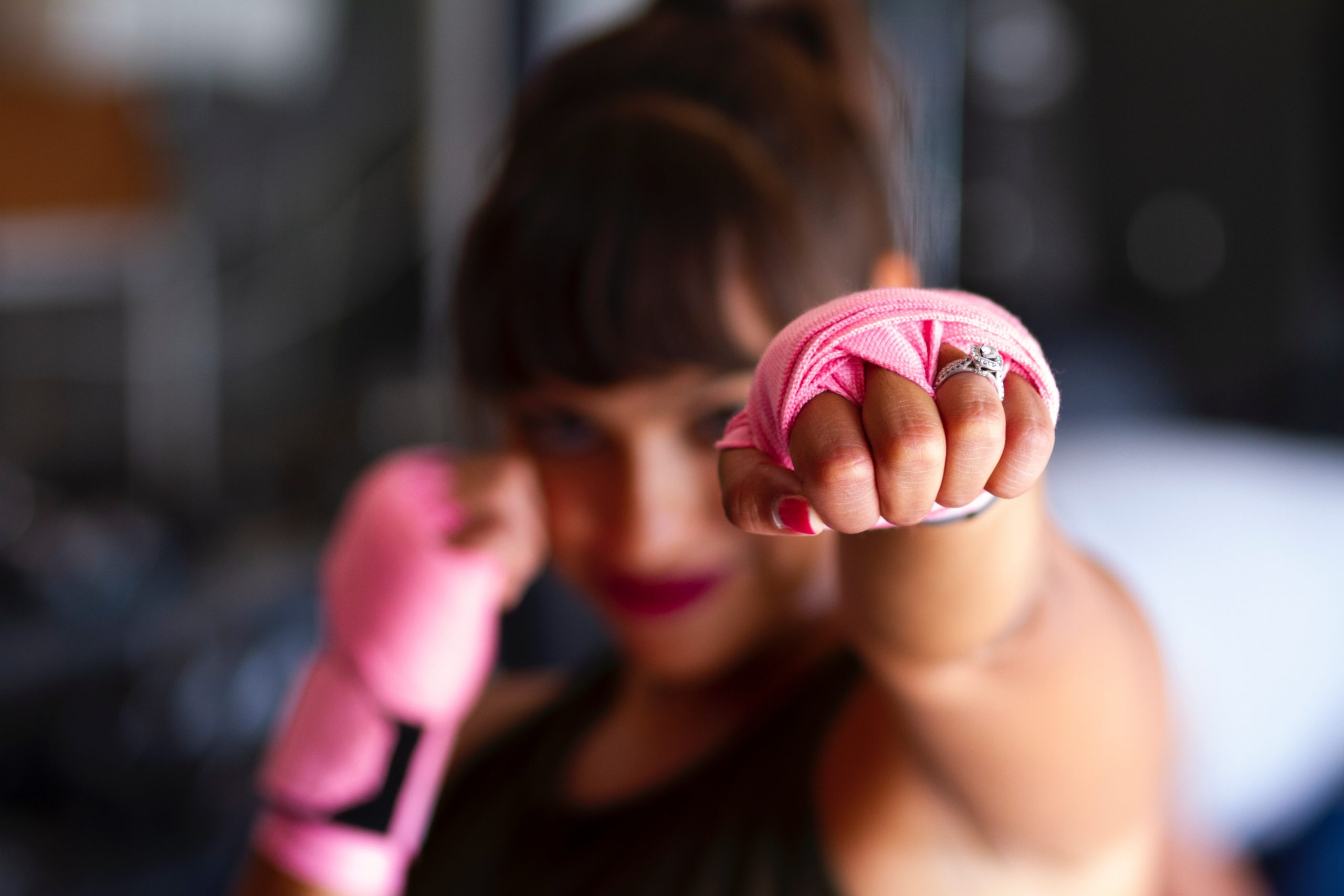 Woman with pink hand wraps air boxing; wraps are pink to represent the Pink Ribbons movement.