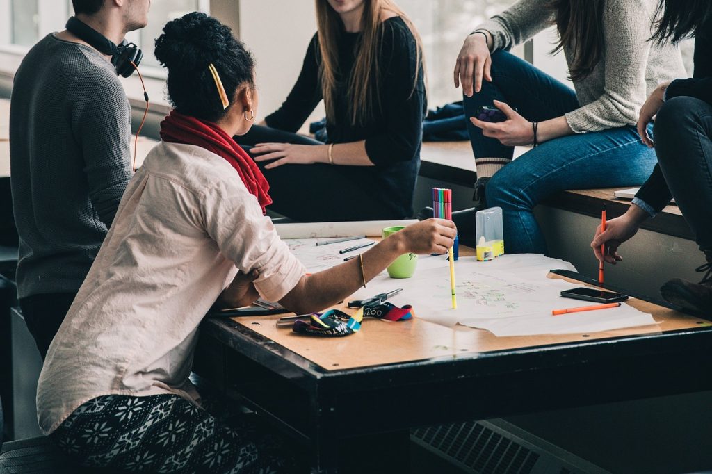 photo of a group of people working together at a large table