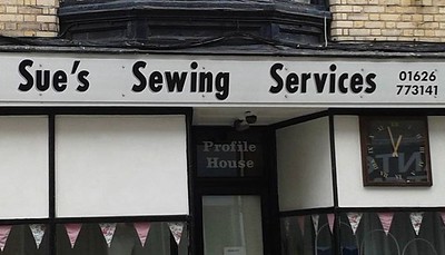 Photo of a store front. The name of the store is "Sue's Sewing Services"