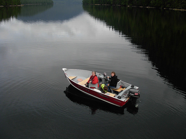 Two women sitting in a Lund boat in a big lake.