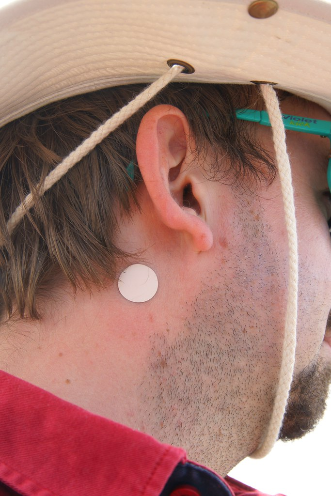 A person with a with transdermal patch behind their right ear.