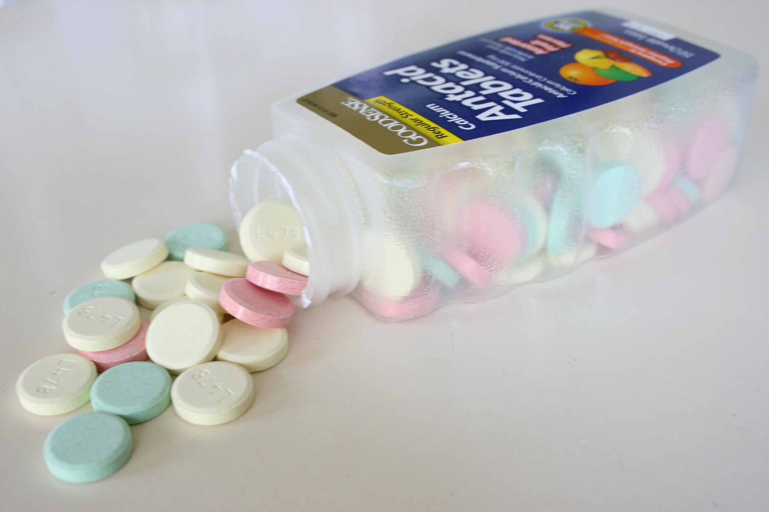 An Antacid tablets bottle resting on side, with contents spilled out.