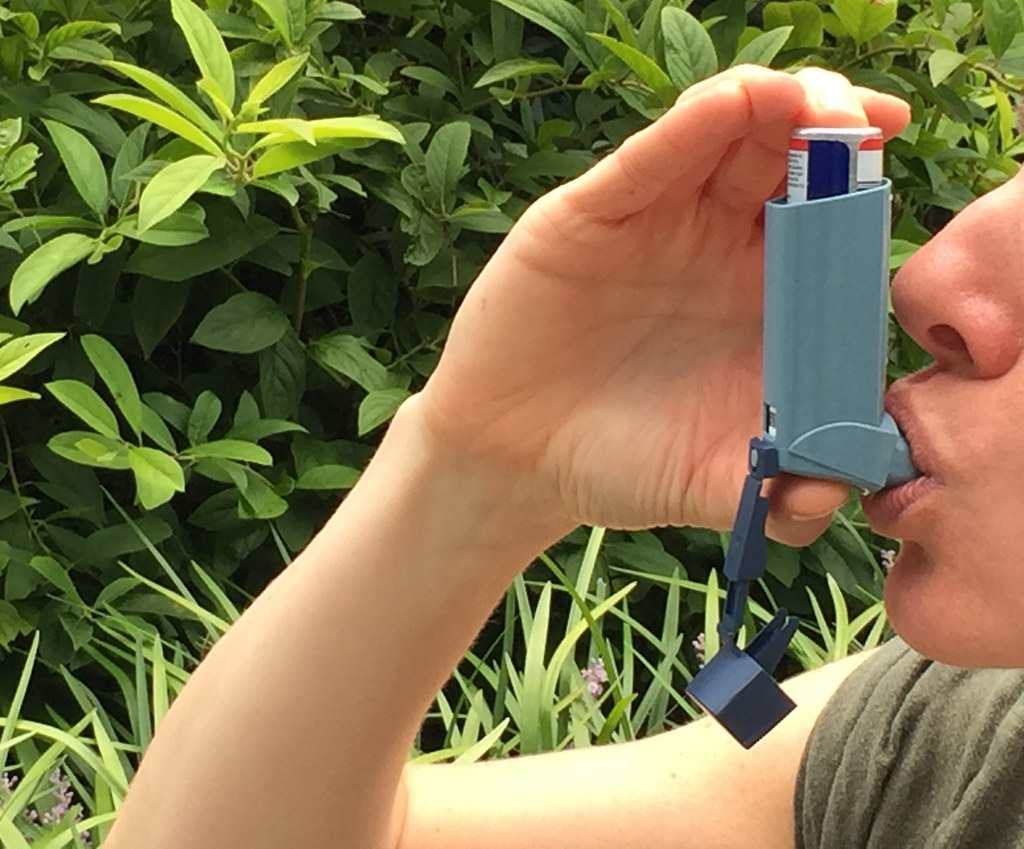 person using a metered dose asthma inhaler