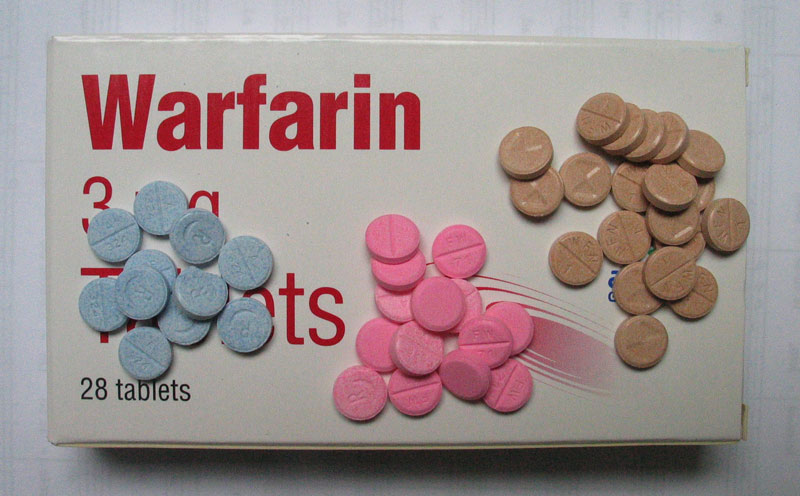 Three piles of Warafin pills that are different colours.
