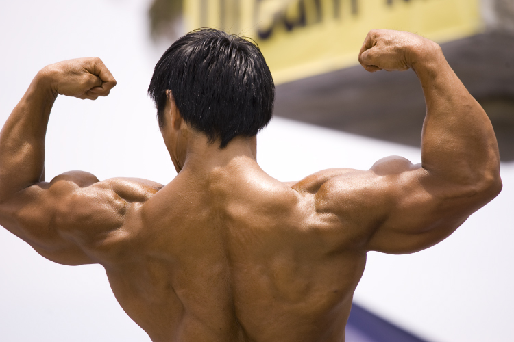 This photograph shows a man flexing his muscles.