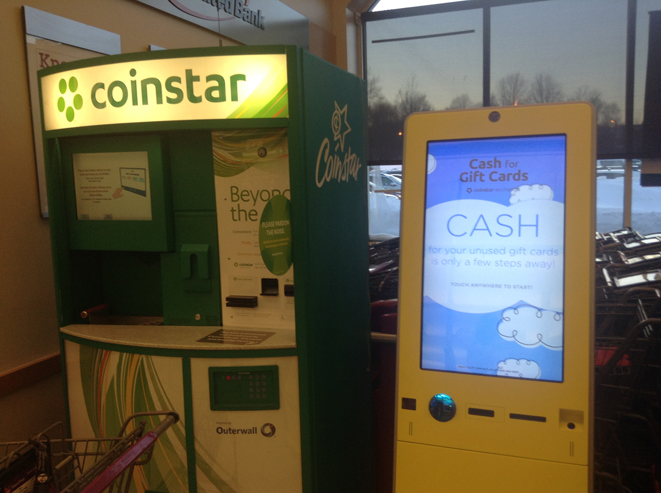 Photograph shows a coin star machine beside a cash for gift cards machine.