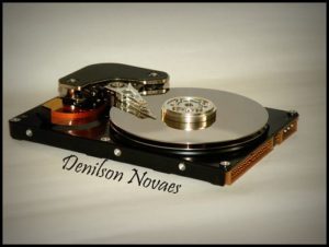 A big metal disk sitting flat beneath a small, angular piece of metal.
