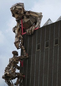 A sculpture of a person helping someone climb a building