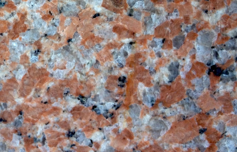 Figure 8.15 Crystals of potassium feldspar (pink) in a granitic rock are candidates for isotopic dating using the K-Ar method because they contained potassium and no argon when they formed. [SE]