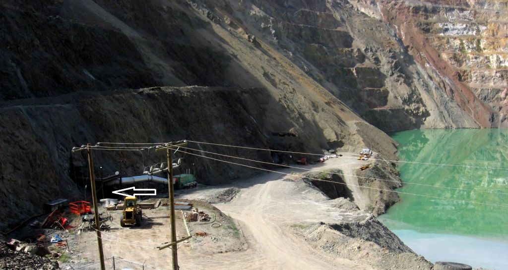 Figure 20.11 Entrance to an exploratory decline (white arrow) for the New Afton Mine situated in the side of the open pit of the old Afton Mine, near Kamloops, B.C. [SE]