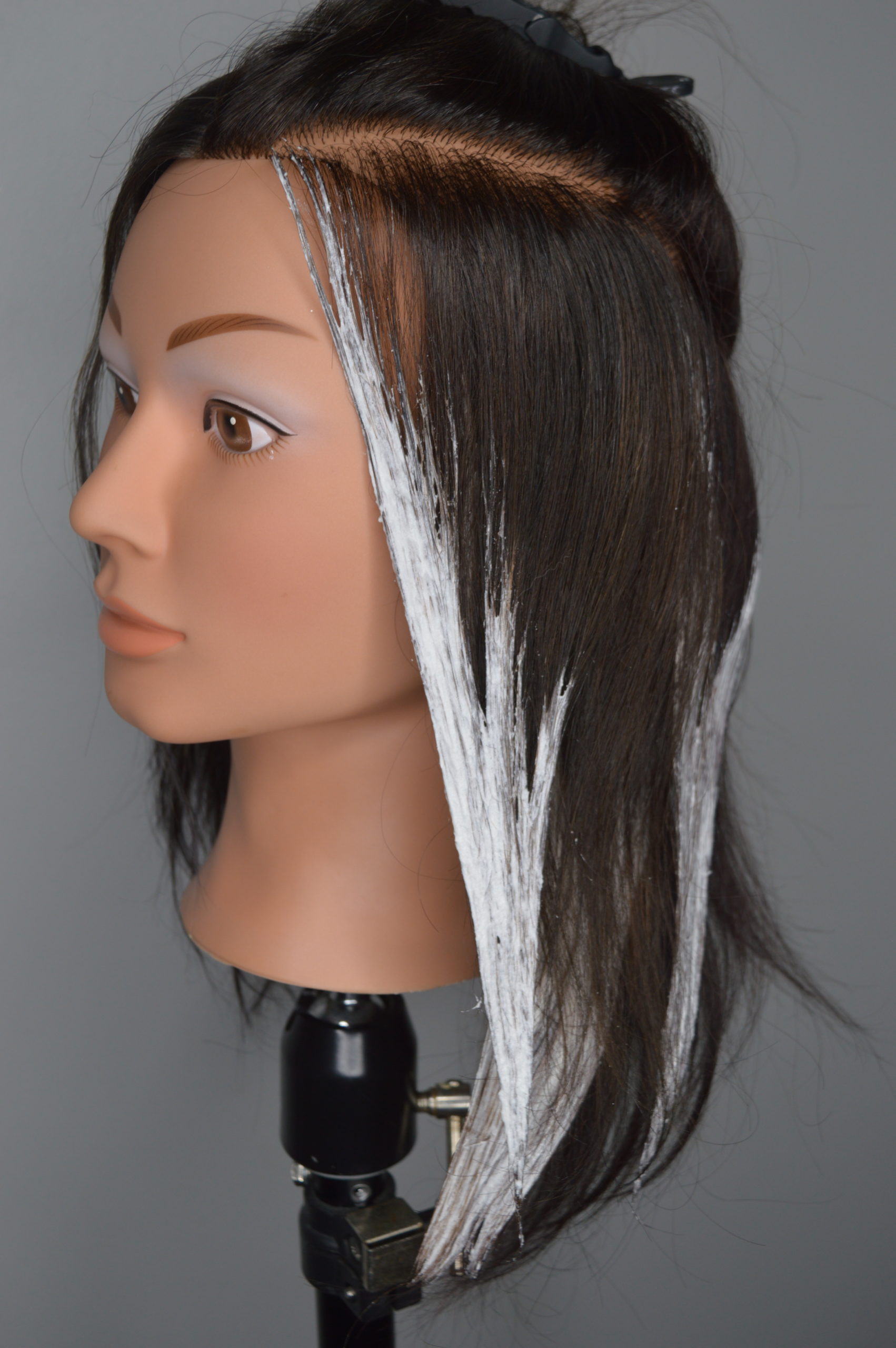Lightener is applied to a large section of hair to form a half-V shape.