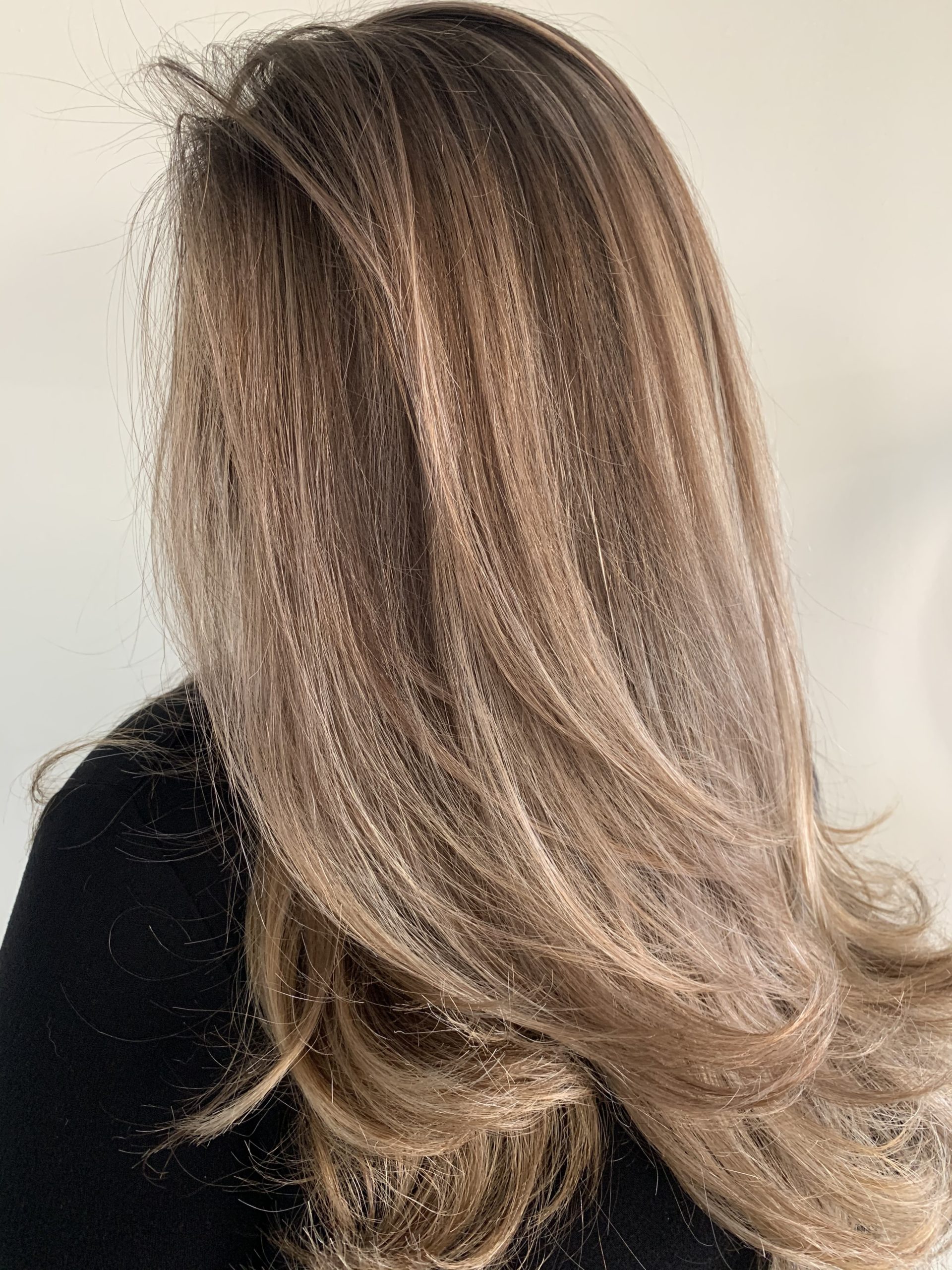 Long hair that is darker at the roots and gradually transitions to blonde. Everything is well blended.