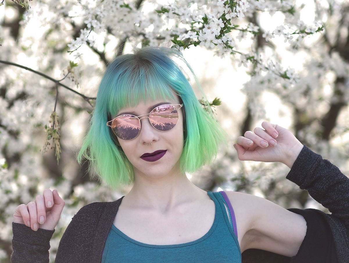 A woman with ombre hair that goes from dark blue at the roots to lime green at the ends.