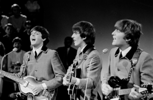 Left to right, Paul McCartney, George Harrison and John Lennon performing in Holland in 1964. Photo shows their distinct "mop top" haircuts that became a popular men's hairstyle in the 1960s.