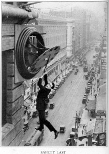 Harold Lloyd hangs from a broken clock above a New York City street in the film, Safety Last.