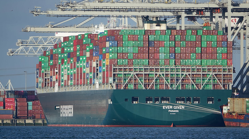 Stern view of the container ship Ever Given at dock showing containers stacked 23 wide and 10 high above deck.