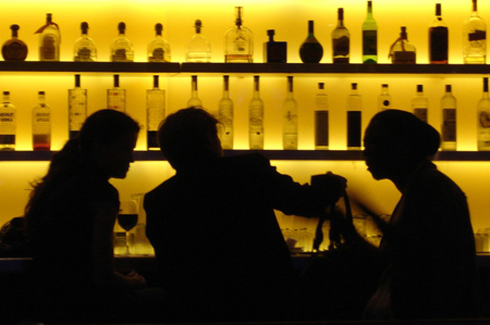 Three people sitting at a bar.