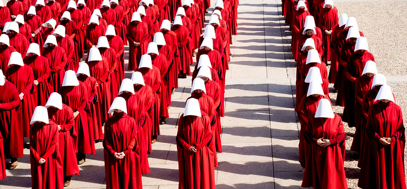 Rows of handmaids in red cloaks and white nun-like hoods from the fiming of a TV series based on Margeret Atwood's Handmaid's Tale (1985).