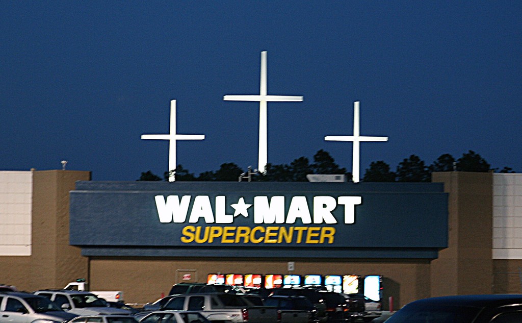 The storefront of a Walmart supercenter with three large crosses behind it.