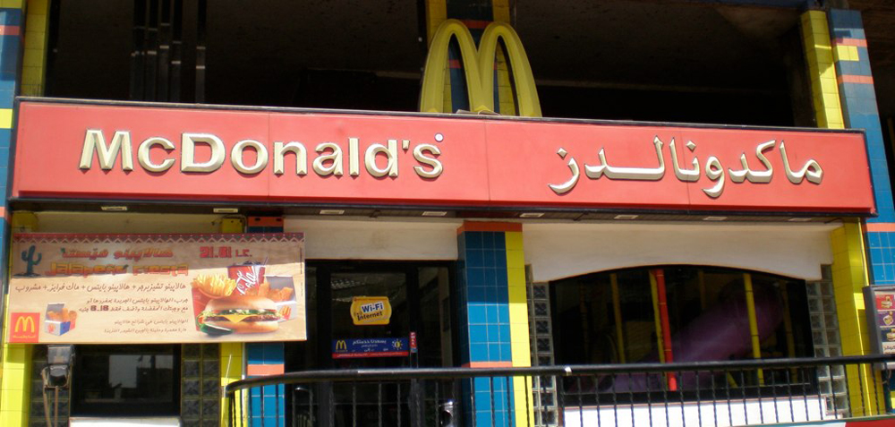 A McDonald&#039;s storefront in Egypt with its name in English and Arabic.