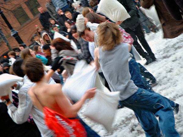 A large pillow fight on the street.