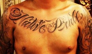 A chest tattoo spelling out &quot;Native Pride.&quot;