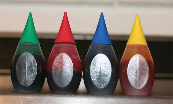 Bottles of green, red, blue, and yellow food colouring.