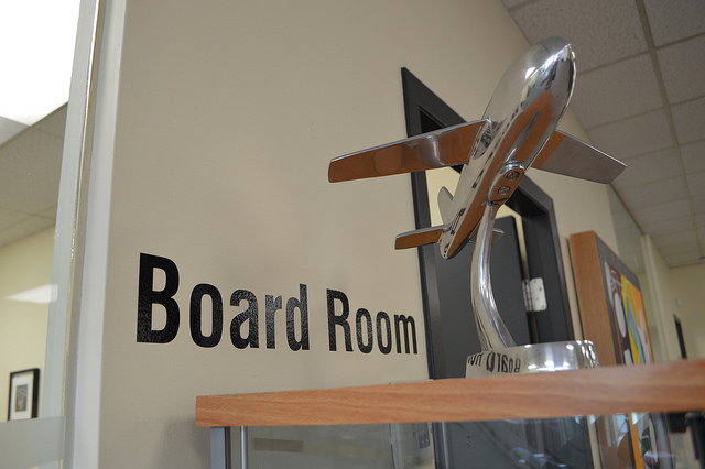 The entry to a Board Room in the Canadian Tourism College with a small air plane statue outside.