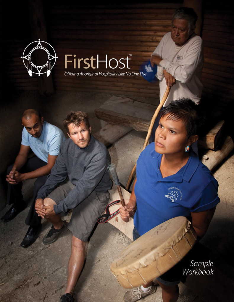 A tour guide beats a deerskin hand drum while guests watch.