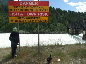 Sign beside a stream. Long description available.