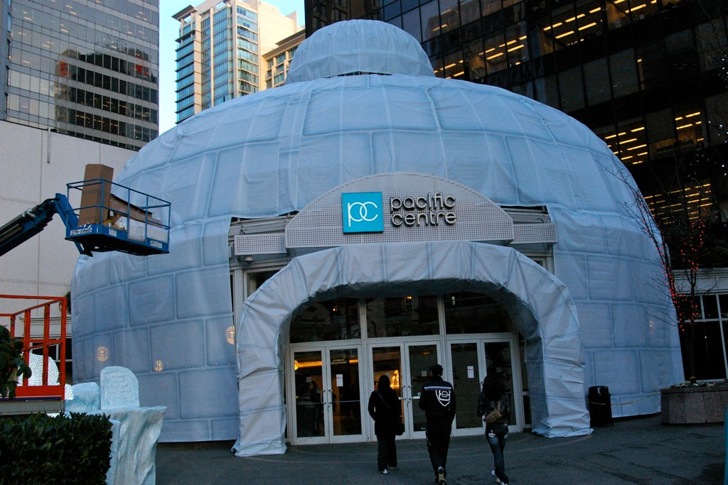 Canvas with a white brick design is draped over a rounded building entrance to resemble an igloo.
