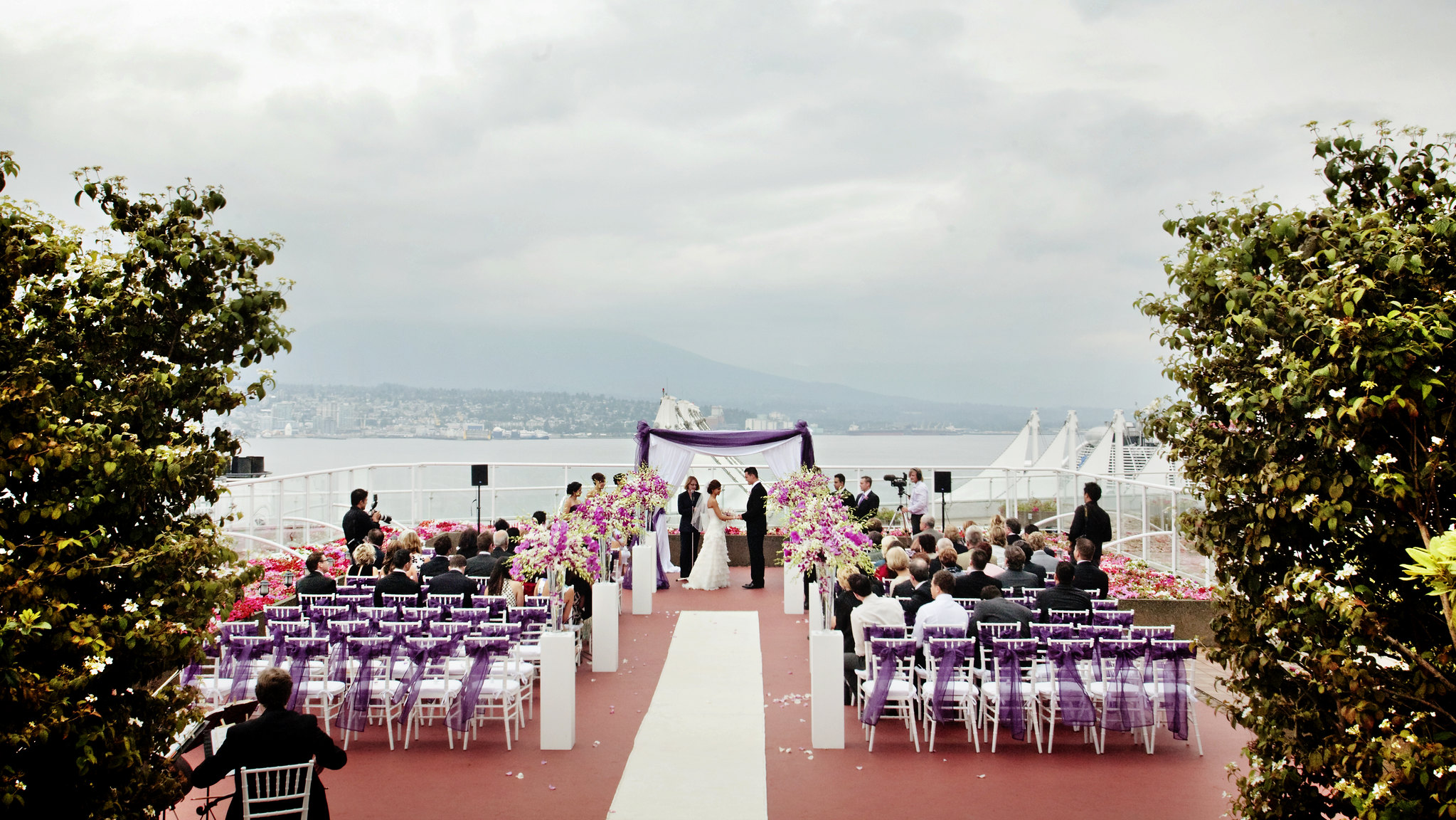 A rooftop wedding. The ocean is visible in the distance.