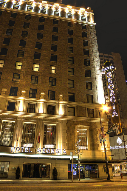 The front of a historic hotel at night. A neon sign says "Hotel Georgia."