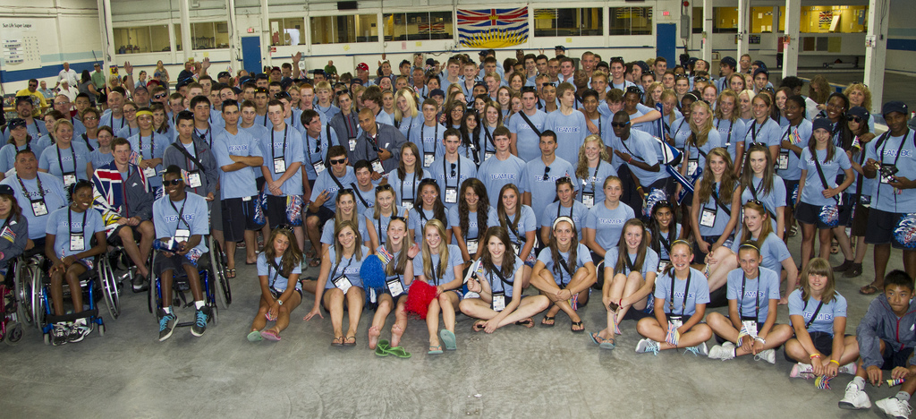A large group of people wearing light blue shirts, athletic shorts, and lanyards.