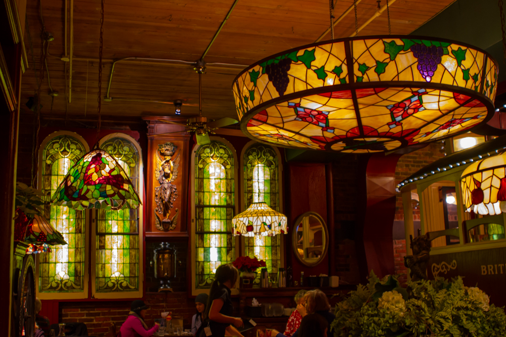 Restaurant interior with many stained glass windows and stained glass light fixtures.