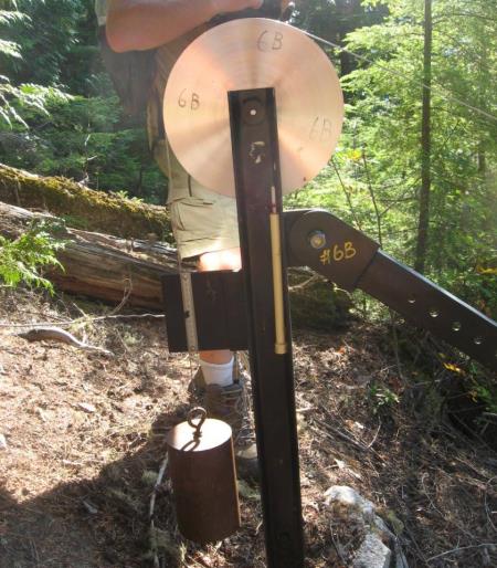 Figure 15.19 Part of a motion-monitoring device at the Checkerboard Slide near Revelstoke, B.C. The lower end of the cable is attached to a block of rock that is unstable. Any incremental motion of that block will move the cable and this will be detectable on this device. [SE]
