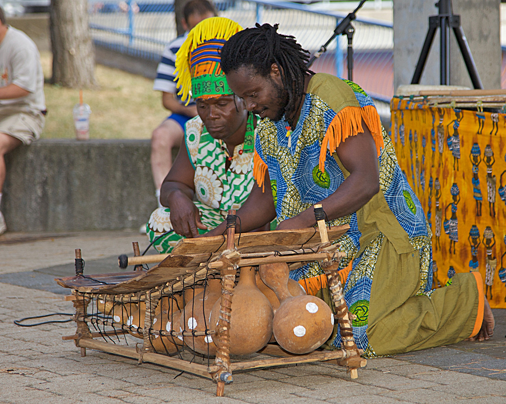 Photograph of two people playing a marimba with gourds as resonance chambers.