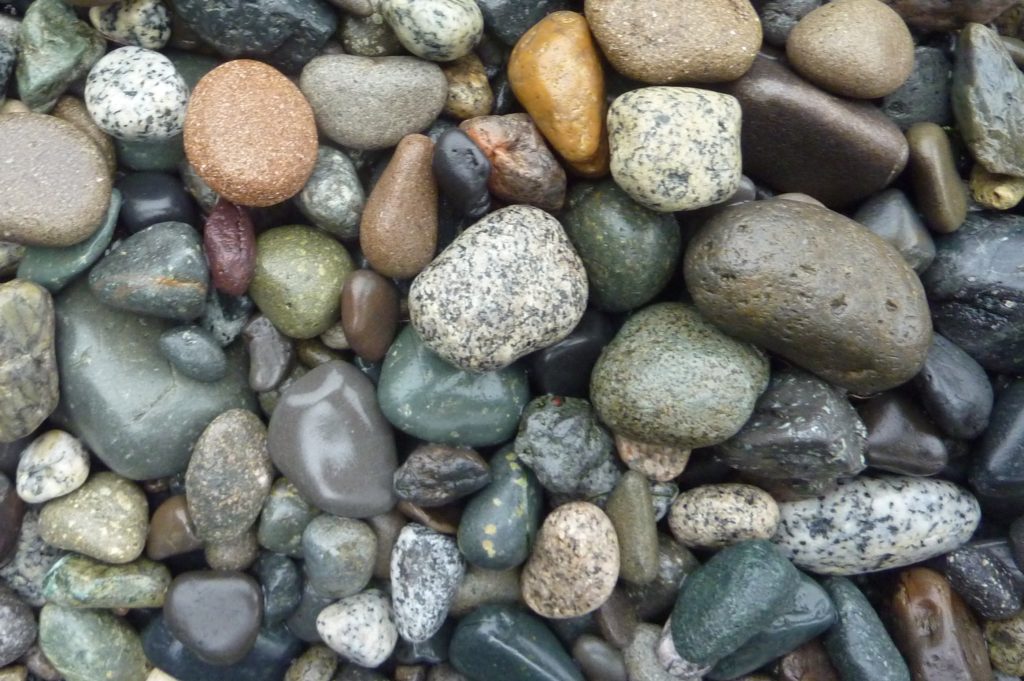 A pile of different coloured rocks. Granite rocks are white with dark specks