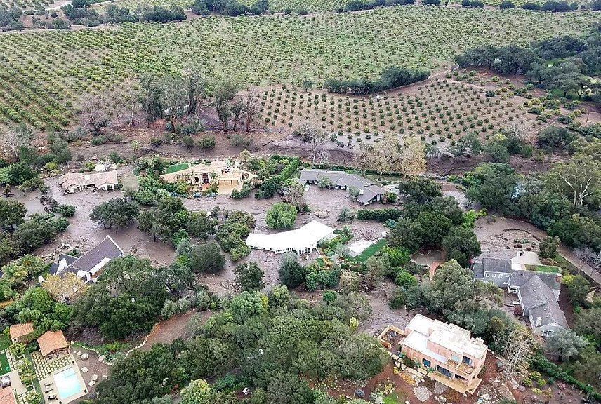 An aerial view of a community engulfed in mud.